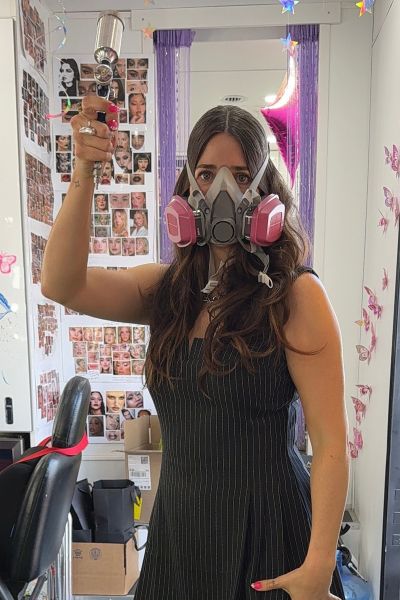 Euphoria head makeup artist Donni Davy with a ventilation mask and an airbrush machine.